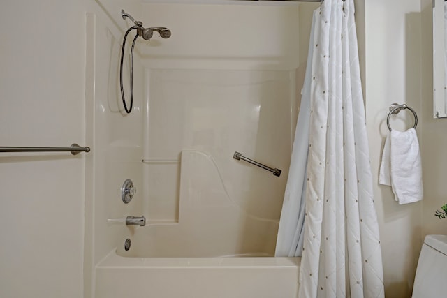 bathroom featuring toilet and shower / bath combination with curtain