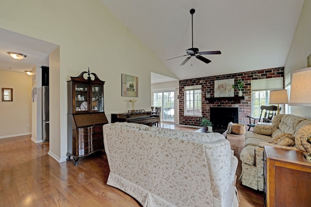 living area with ceiling fan, baseboards, a healthy amount of sunlight, and wood finished floors