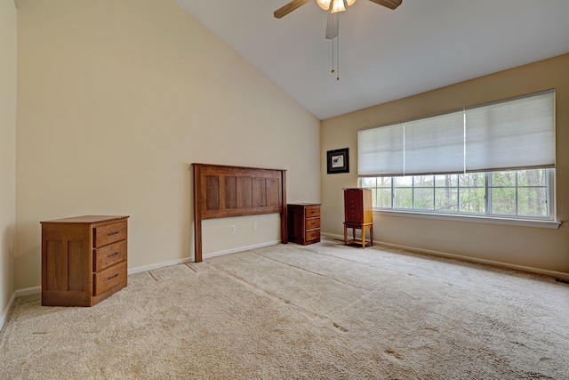 unfurnished bedroom with baseboards, a ceiling fan, high vaulted ceiling, and carpet floors