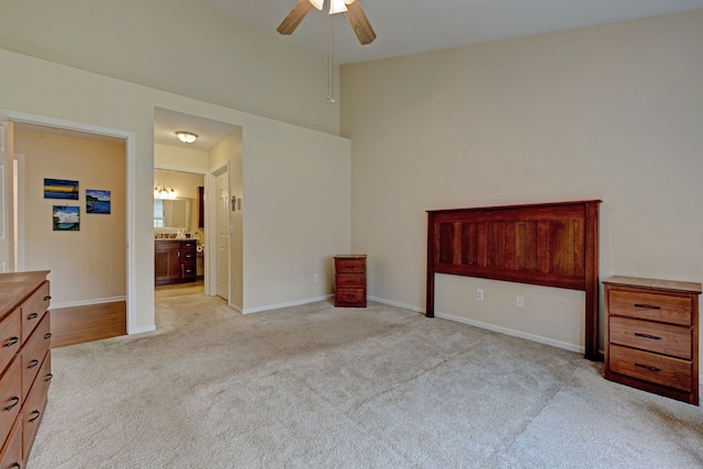 unfurnished bedroom featuring baseboards, ensuite bathroom, and light carpet