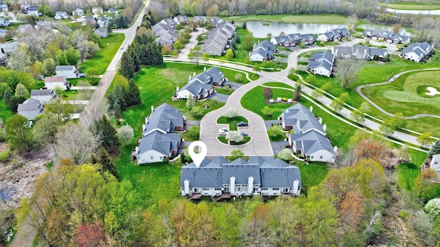 drone / aerial view featuring a water view, golf course view, and a residential view