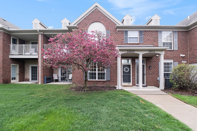 29720 Heritage Pkwy, Warren, MI 48092 - view of front of house featuring a balcony, a front yard, and brick siding