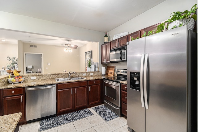 kitchen with a sink, stainless steel appliances, visible vents, light stone countertops, and light tile patterned flooring