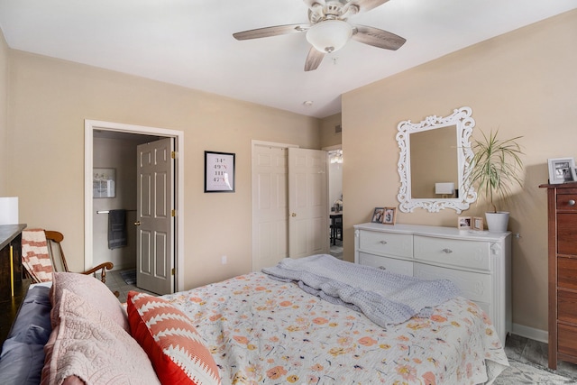 bedroom featuring ensuite bathroom, baseboards, and ceiling fan
