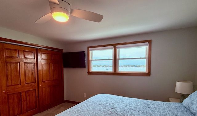 bedroom featuring light carpet, baseboards, and a ceiling fan