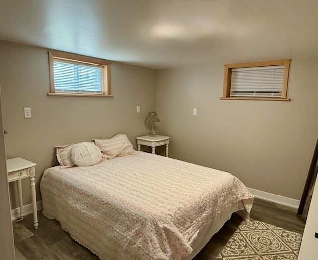 bedroom featuring baseboards and dark wood finished floors