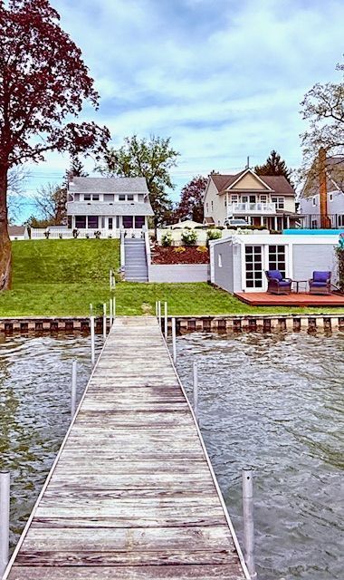 dock area with a water view and a lawn