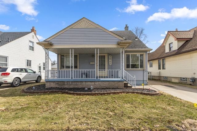 bungalow with covered porch and a front yard
