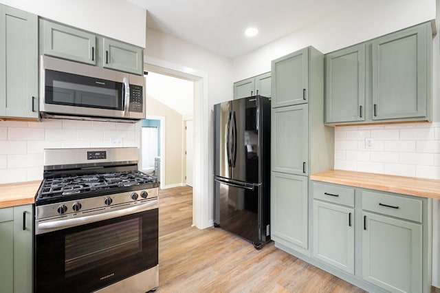 kitchen with wood counters, light wood-style flooring, green cabinets, and appliances with stainless steel finishes