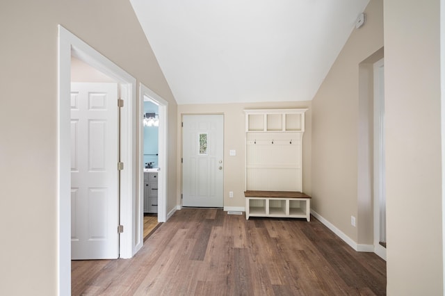 entryway featuring vaulted ceiling, baseboards, and wood finished floors