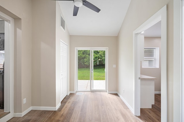 doorway featuring ceiling fan, baseboards, and wood finished floors