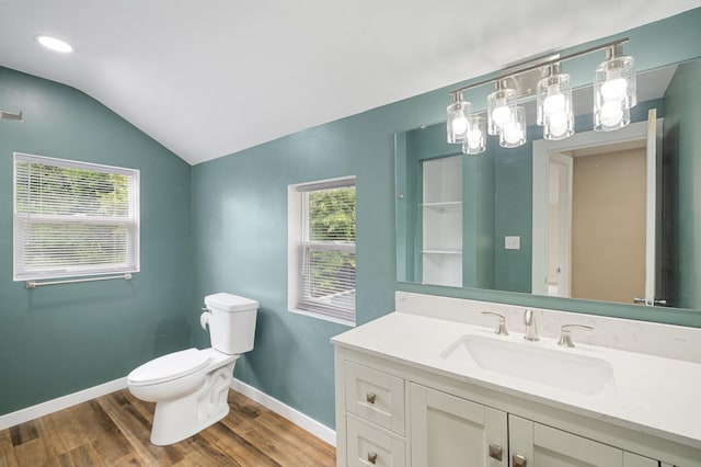 bathroom with toilet, wood finished floors, baseboards, lofted ceiling, and vanity