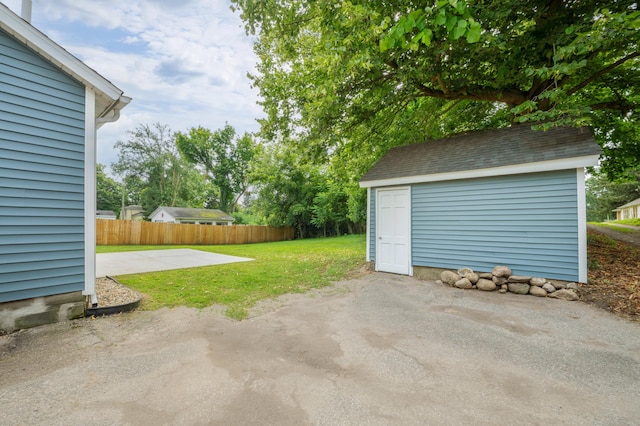 exterior space featuring a shed, fence, and an outbuilding