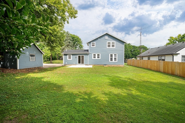 rear view of house featuring a yard, a patio area, and fence