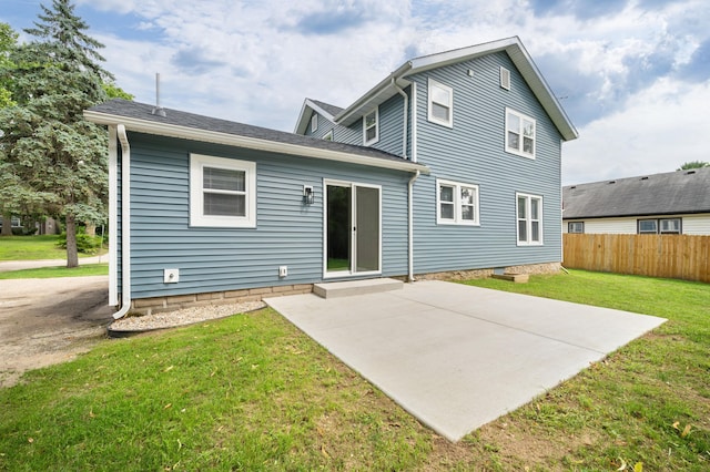 back of property with a patio, fence, and a lawn