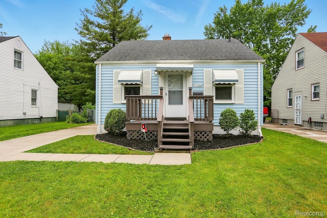 19436 Elkhart St, Harper Woods, MI 48225 - view of front of home with a front lawn, a chimney, and roof with shingles