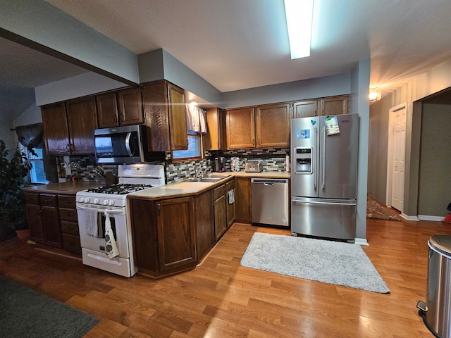 3544 Burnsline Rd, Brown City, MI 48416 - kitchen featuring a sink, stainless steel appliances, decorative backsplash, and light wood-type flooring