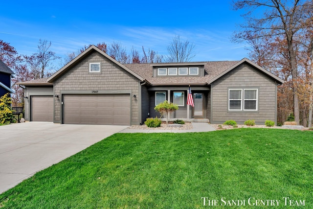 view of front facade featuring roof with shingles, concrete driveway, an attached garage, and a front yard