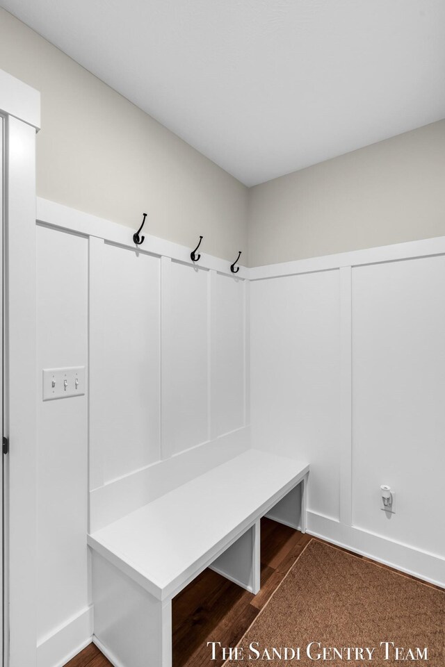 mudroom featuring baseboards and dark wood-type flooring