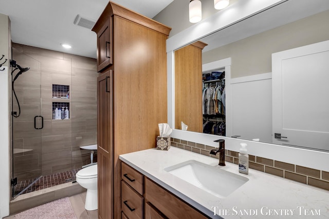 full bathroom featuring toilet, visible vents, a shower stall, vanity, and tasteful backsplash