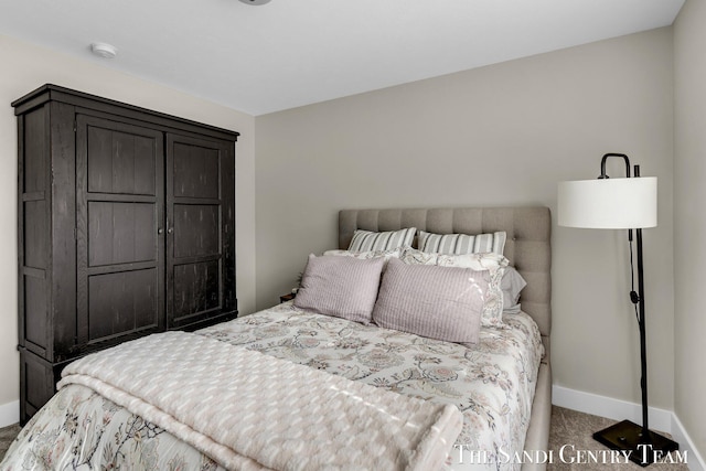 bedroom with baseboards and carpet