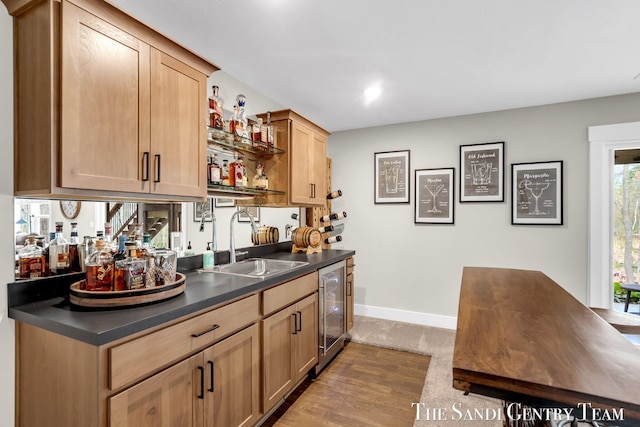 bar featuring bar area, beverage cooler, baseboards, a sink, and dark wood-type flooring