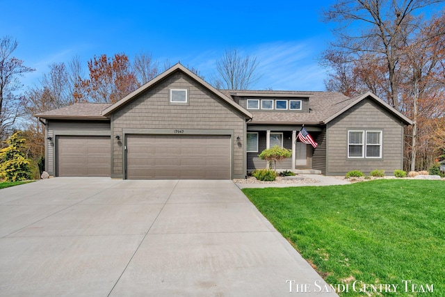 craftsman inspired home featuring an attached garage, a front lawn, a shingled roof, and driveway