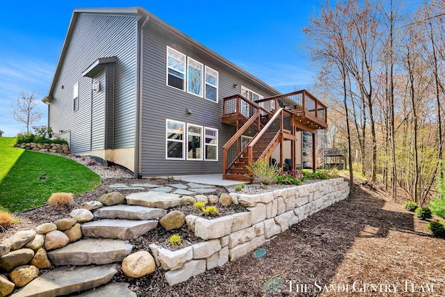rear view of house with stairway, a deck, and a patio