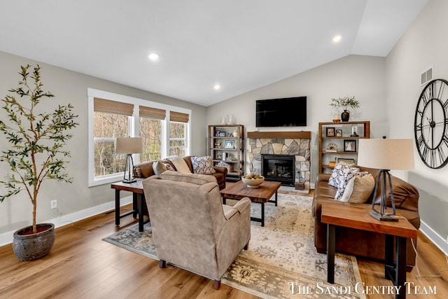 living room with lofted ceiling, baseboards, visible vents, and wood finished floors