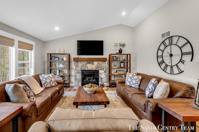 living area with lofted ceiling, light wood-style flooring, recessed lighting, visible vents, and a fireplace