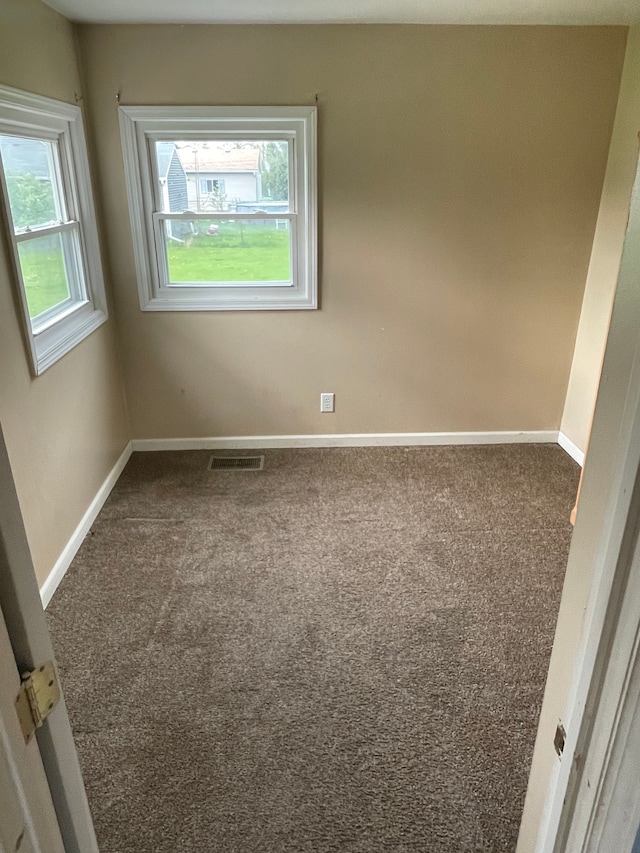 unfurnished room with baseboards, carpet flooring, and visible vents