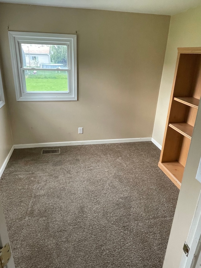 spare room with visible vents, baseboards, and carpet floors