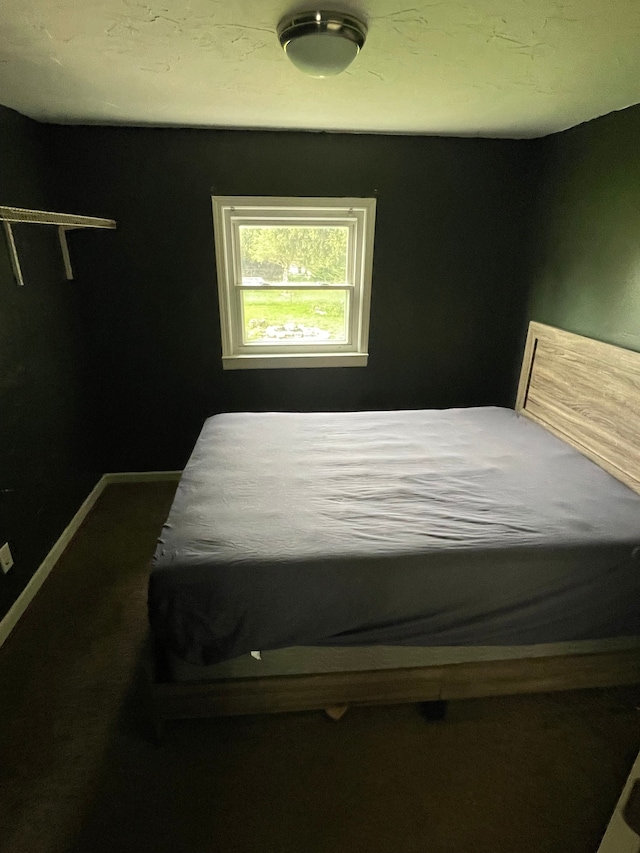 bedroom featuring baseboards and dark colored carpet