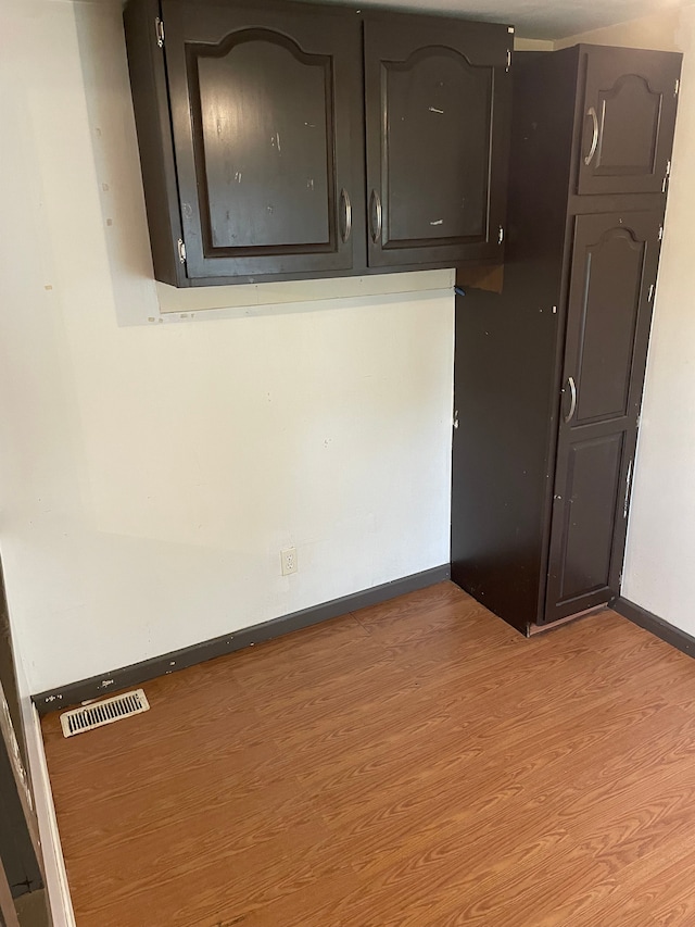 interior space featuring light wood-style floors, visible vents, and baseboards