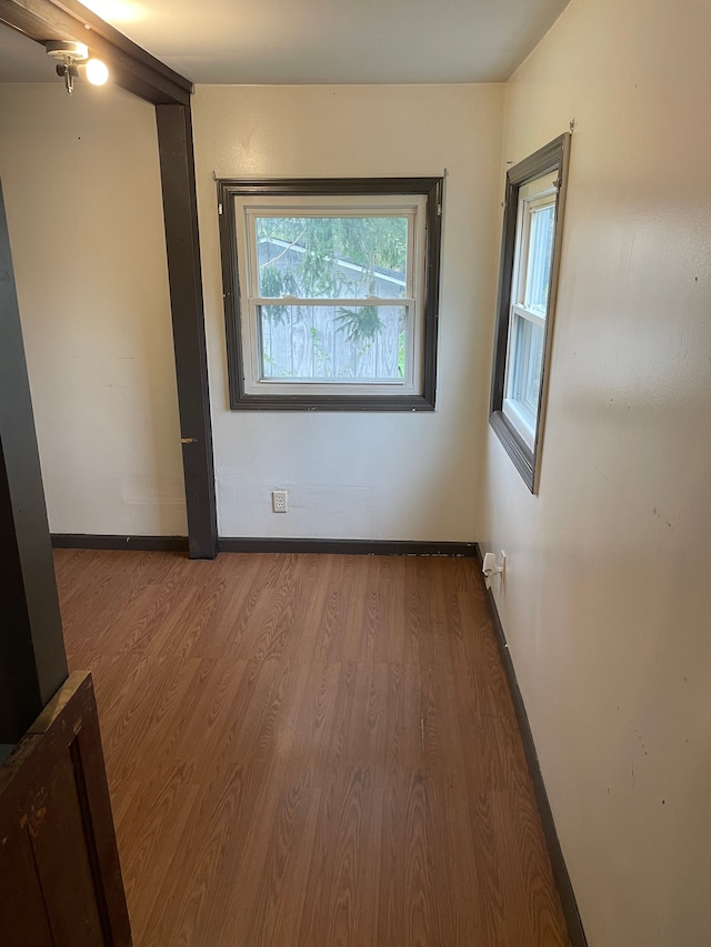 unfurnished room with wood finished floors and baseboards