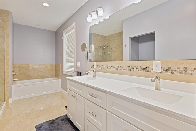 bathroom featuring a sink, double vanity, a stall shower, and a garden tub