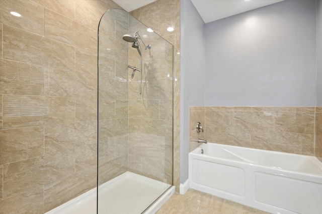 bathroom with a bath and a tile shower