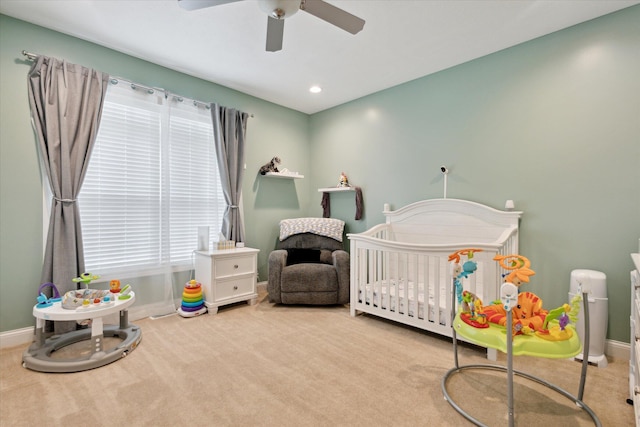 bedroom featuring carpet flooring, a nursery area, and baseboards