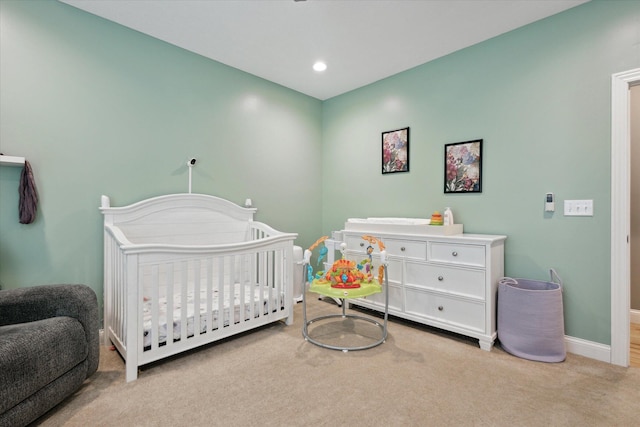 bedroom with recessed lighting, a nursery area, baseboards, and carpet floors
