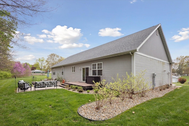 back of house with a yard, a patio area, roof with shingles, and outdoor lounge area