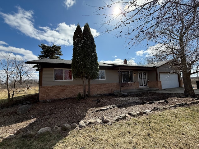 15183 Yale Rd, Lynn, MI 48097 - ranch-style home featuring a chimney, driveway, brick siding, and an attached garage