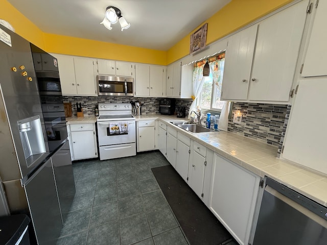 15183 Yale Rd, Lynn, MI 48097 - kitchen featuring a sink, tasteful backsplash, white cabinetry, dark tile patterned flooring, and appliances with stainless steel finishes