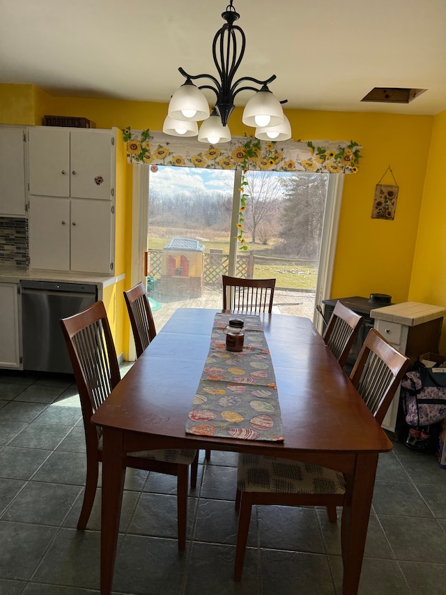 15183 Yale Rd, Lynn, MI 48097 - dining space with a wealth of natural light, an inviting chandelier, and dark tile patterned floors
