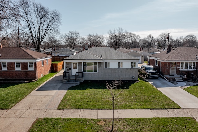 view of front of property with a front lawn, brick siding, driveway, and a residential view