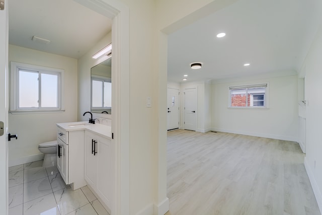 bathroom featuring a wealth of natural light, toilet, baseboards, and vanity
