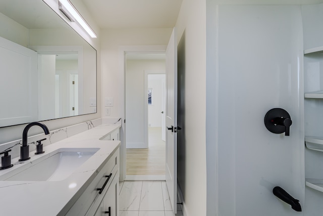 bathroom with baseboards, marble finish floor, and vanity