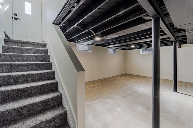 basement featuring stairway and baseboards