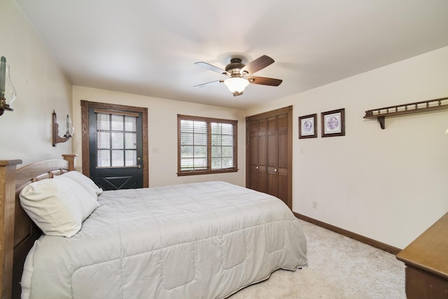 bedroom with light colored carpet, a closet, baseboards, and a ceiling fan