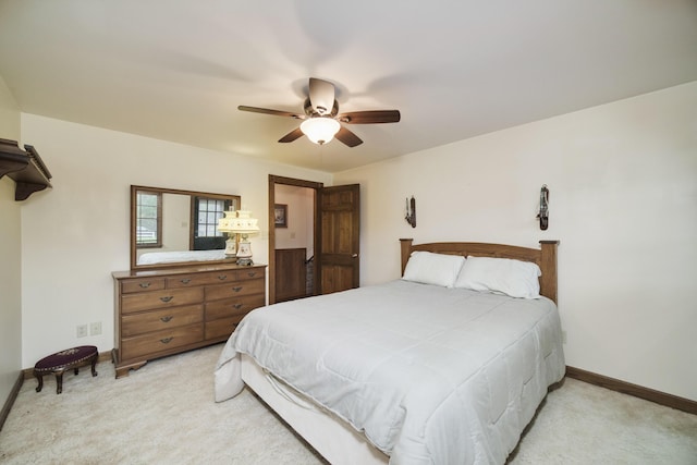 bedroom with ceiling fan, light carpet, and baseboards