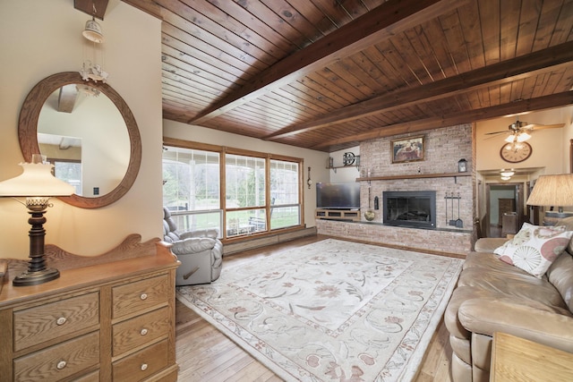 living room with wood ceiling, beam ceiling, a brick fireplace, light wood-type flooring, and ceiling fan